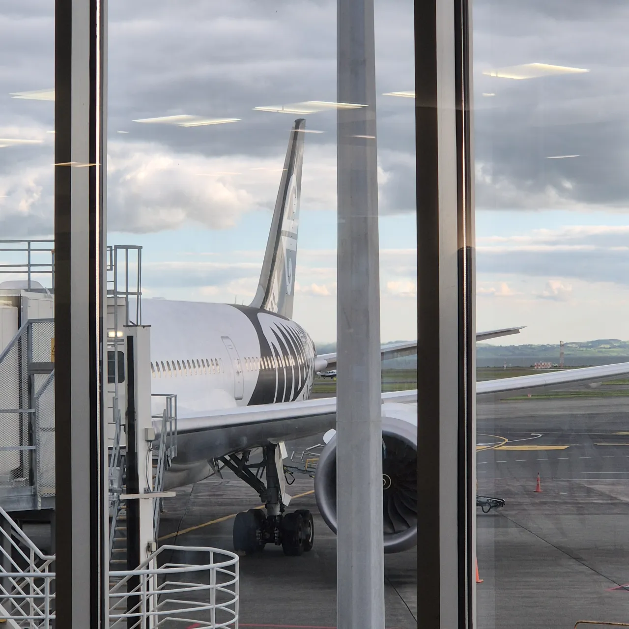 View of the tail end of an Air New Zealand plane at a gate.